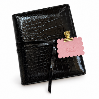 Black croc embossed Elali journal with wrap tie and pink Elali keepsake tag on white background, no optional charms