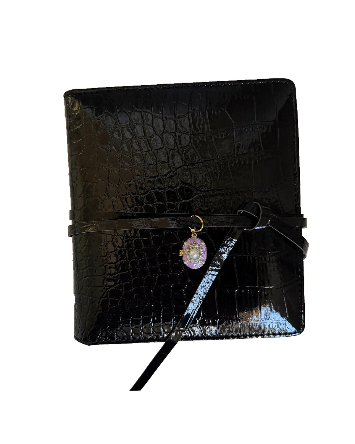 Black croc embossed Elali journal with purple pearl locket charm on a clean white background