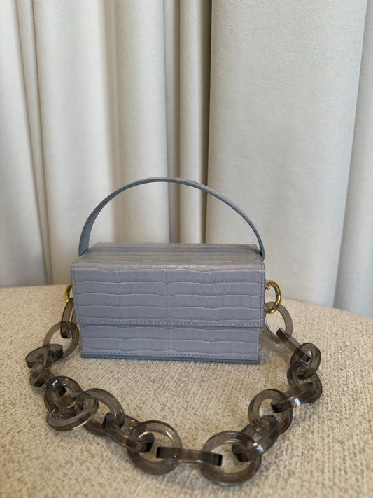 L’AFSHAR Ida light grey embossed leather bag front view with lucite chain